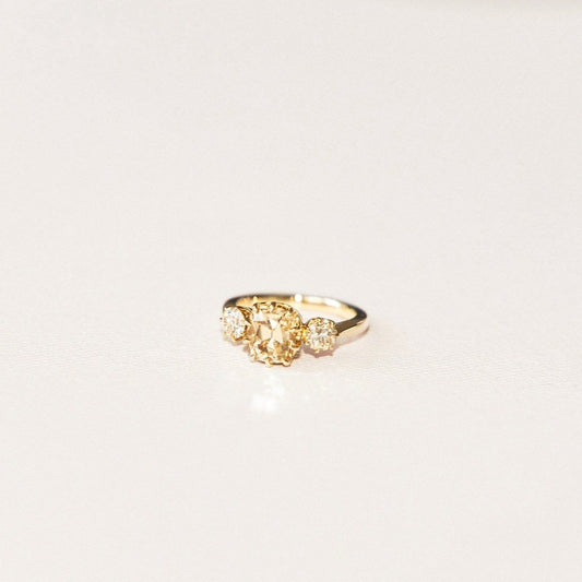 A gold ring featuring a central champagne diamond with bubble-like diamond accents on a white background.