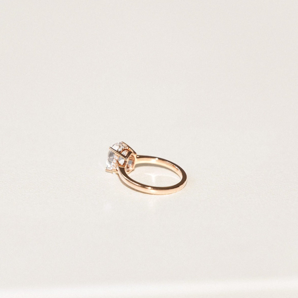 white oval sapphire engagement ring with hidden diamond halo in yellow gold setting