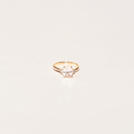Oval sapphire engagement ring with two side diamonds in a three-stone setting.