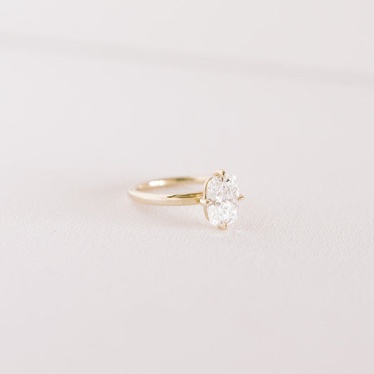 A cushion-cut lab diamond ring with a 14k yellow gold band, featuring a compass setting.