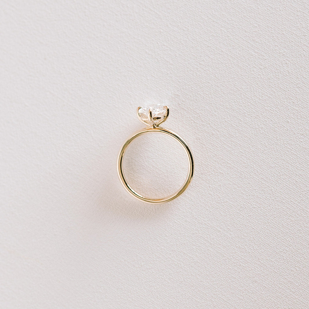 Northstar engagement ring featuring cushion-cut lab diamond in a compass setting, 14k yellow gold band.