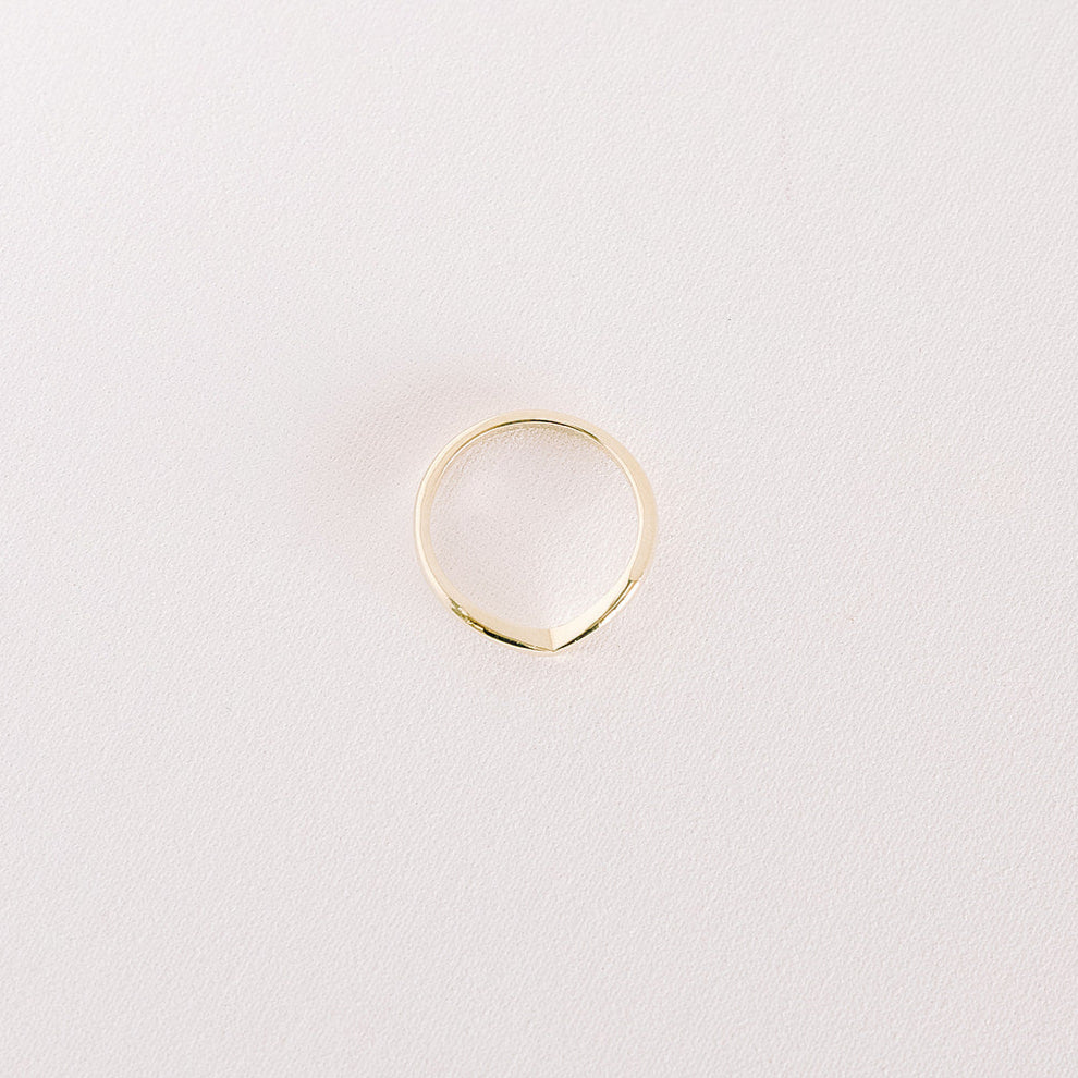 Top view of Veil curved gold wedding band for stacking with engagement rings.