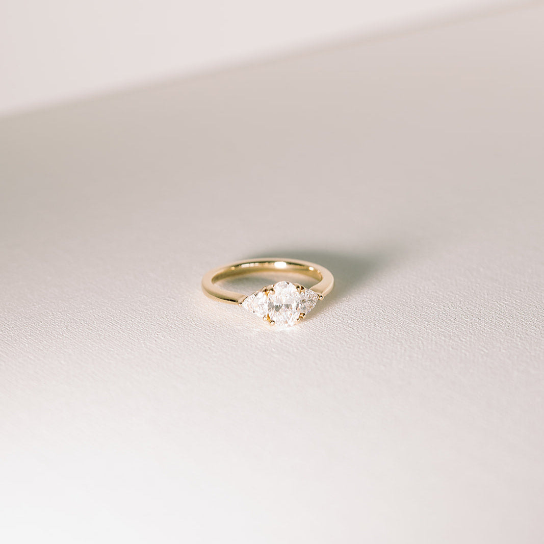 Gold band with three clear center stones, photographed against a light background.