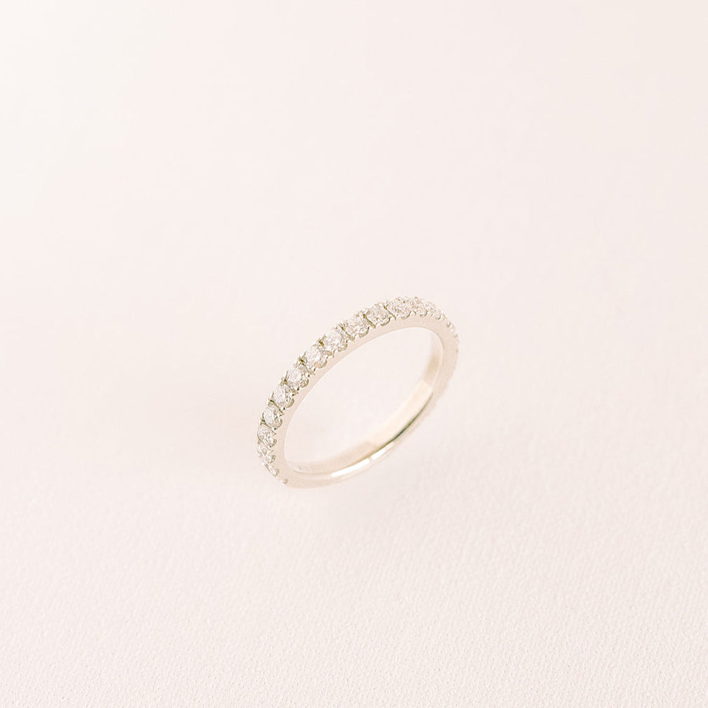 Betrothed — eternity diamond wedding band in yellow gold, angled side view on light background.