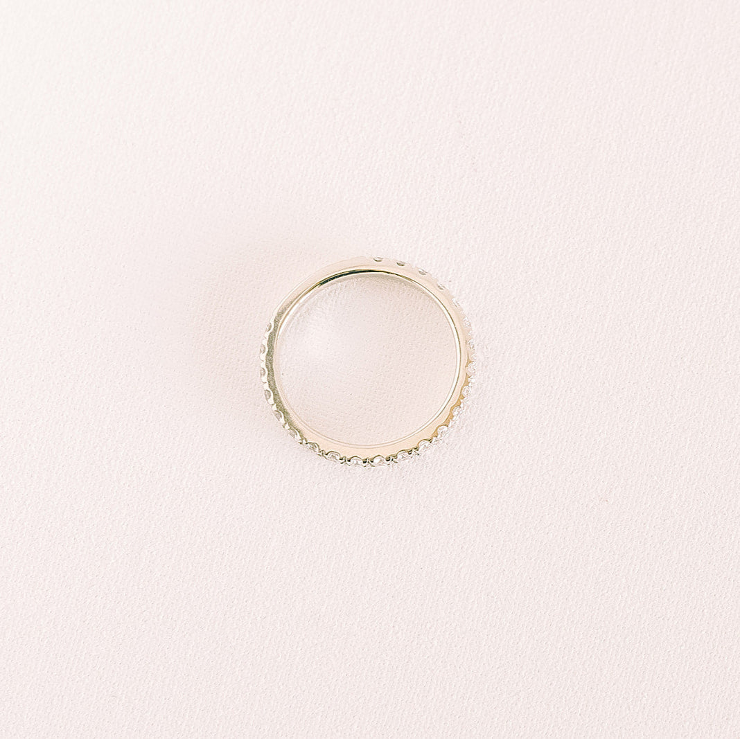 Betrothed — classic eternity diamond wedding band in yellow gold, top-down view against a light background.