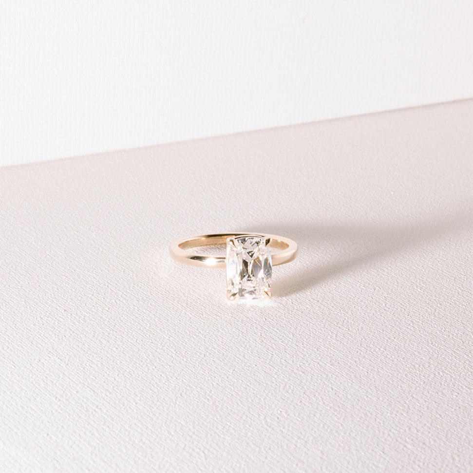 Heirloom engagement ring featuring elongated old mine cut lab diamond set in 14k yellow gold.
