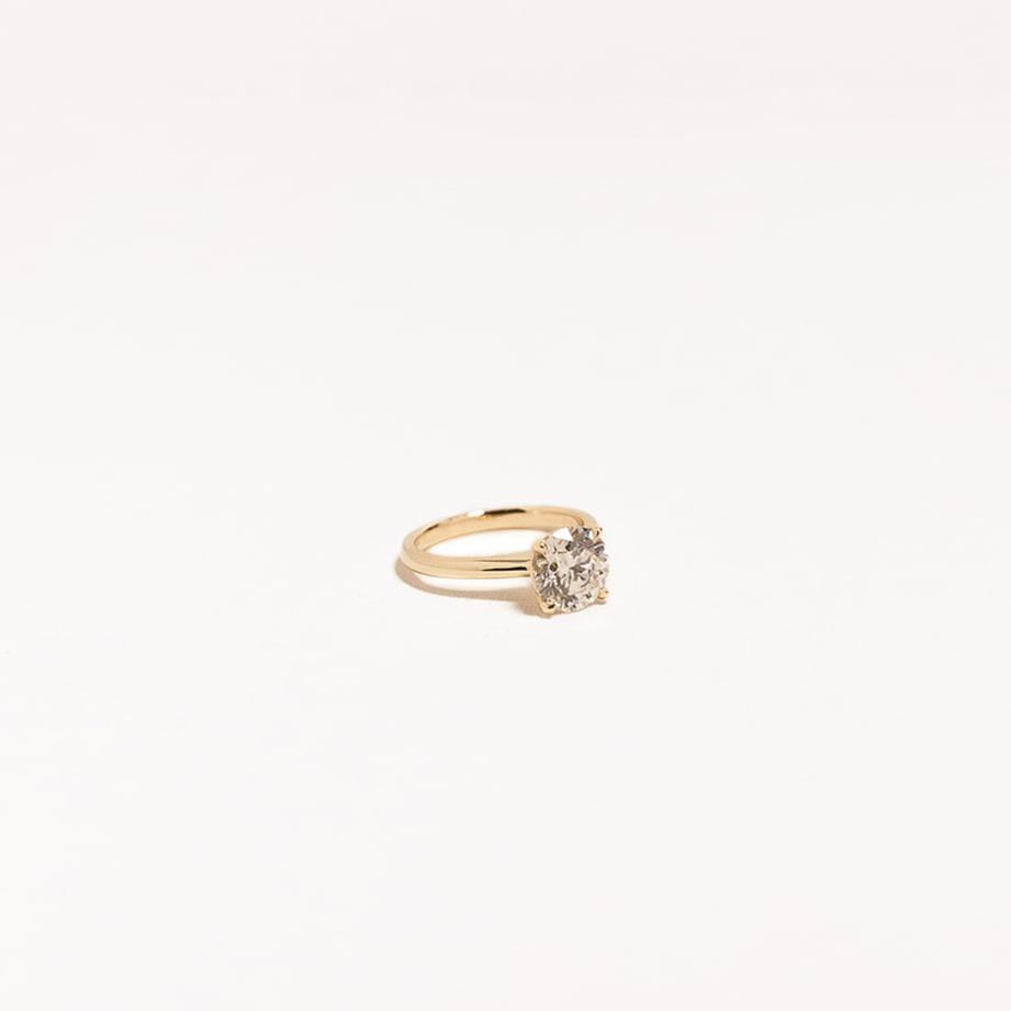 Side angle of 14k yellow gold solitaire ring with 2.01 carat round lab diamond, elegant and timeless design.
