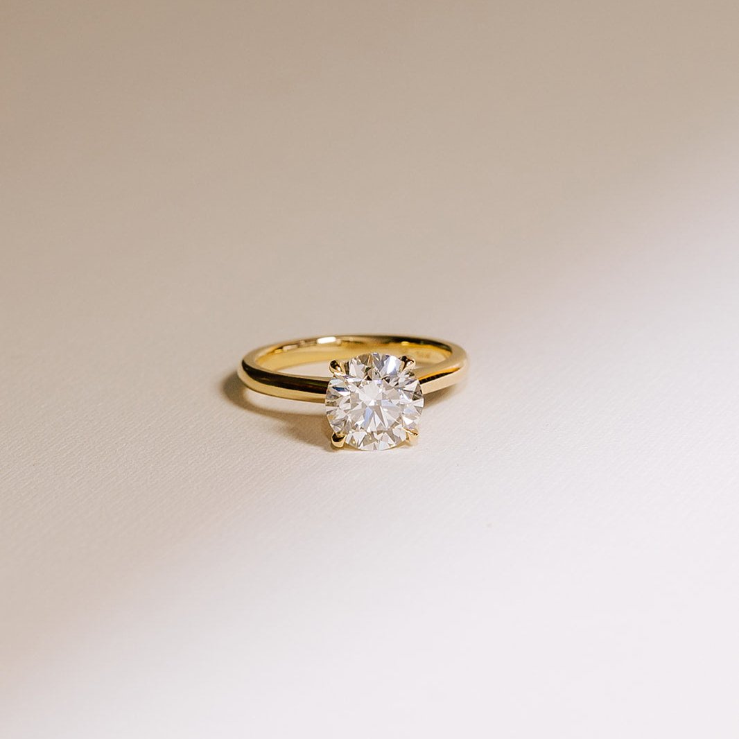Close-up of round solitaire lab diamond ring in 14k yellow gold, highlighting the 2.01 carat diamond’s fire and clarity.