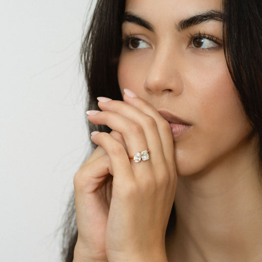 Blissed Out toi et moi engagement ring with pear-shaped and radiant-cut lab diamonds, worn on hand.