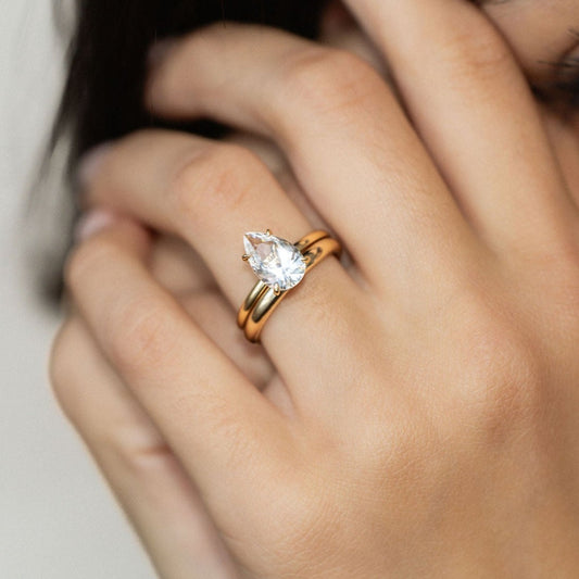 Pear-cut sapphire engagement ring in a gold solitaire setting.