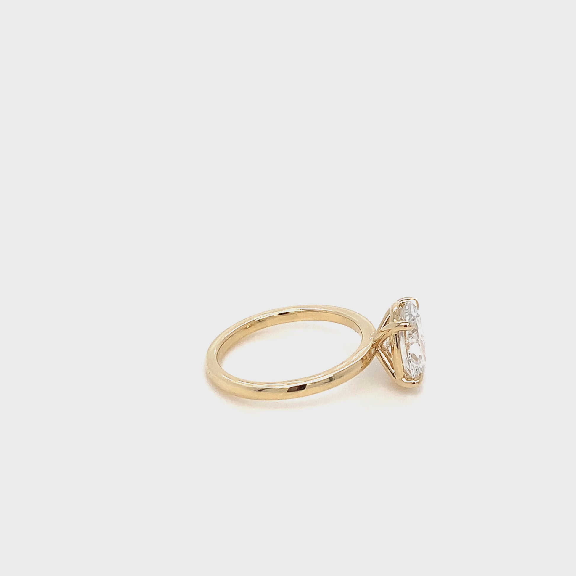 Rotating view of the Over the Moon ring, an oval solitaire lab diamond set in a 14k yellow gold band against a white background.