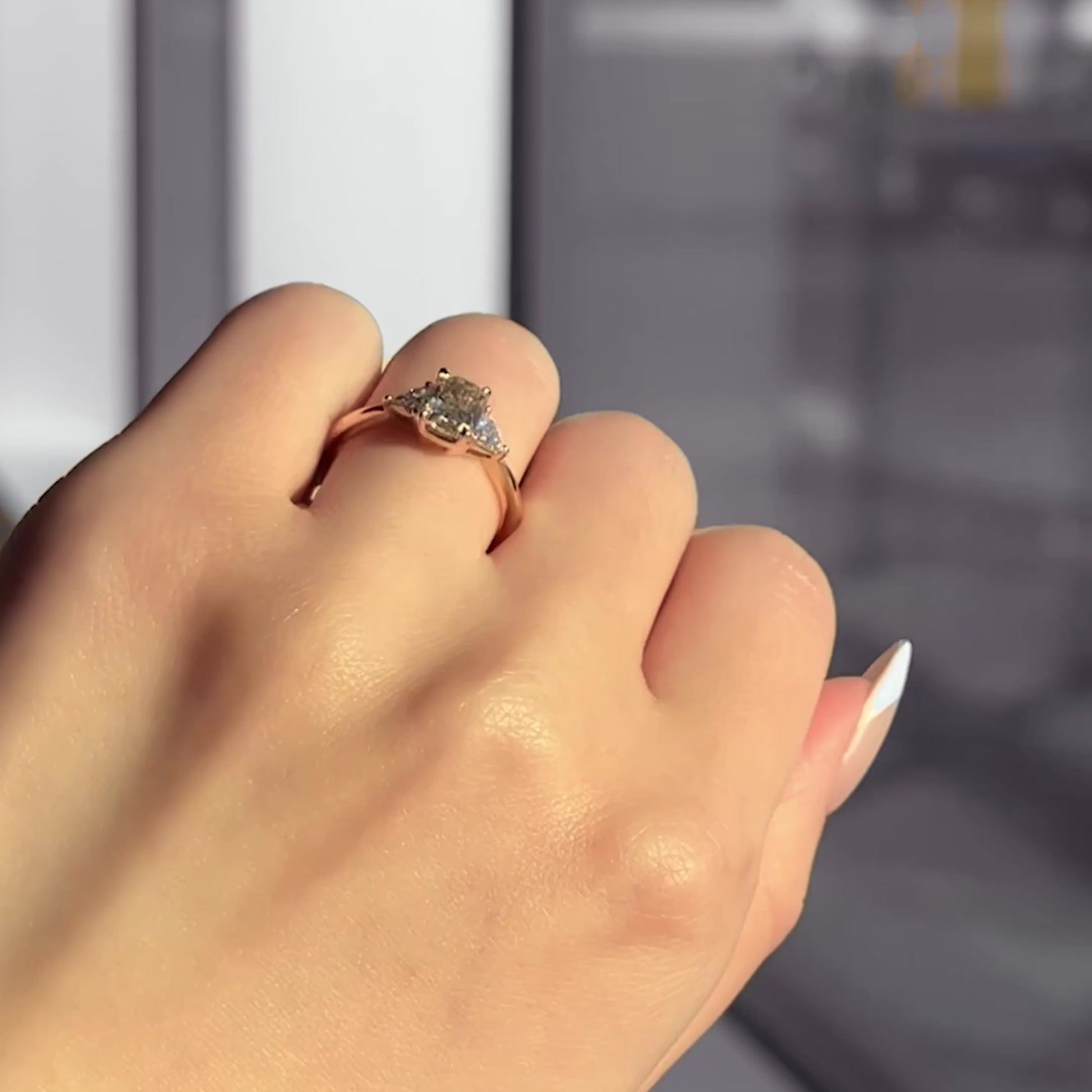 Yellow cushion-cut diamond engagement ring with trilliant side stones in yellow gold.