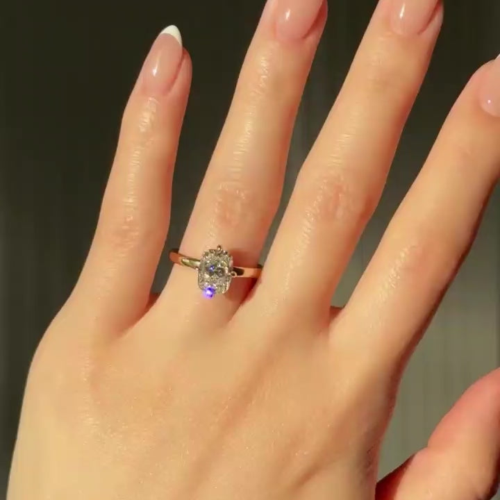 Hand wearing cushion-cut lab-grown diamond engagement ring in yellow gold compass setting.