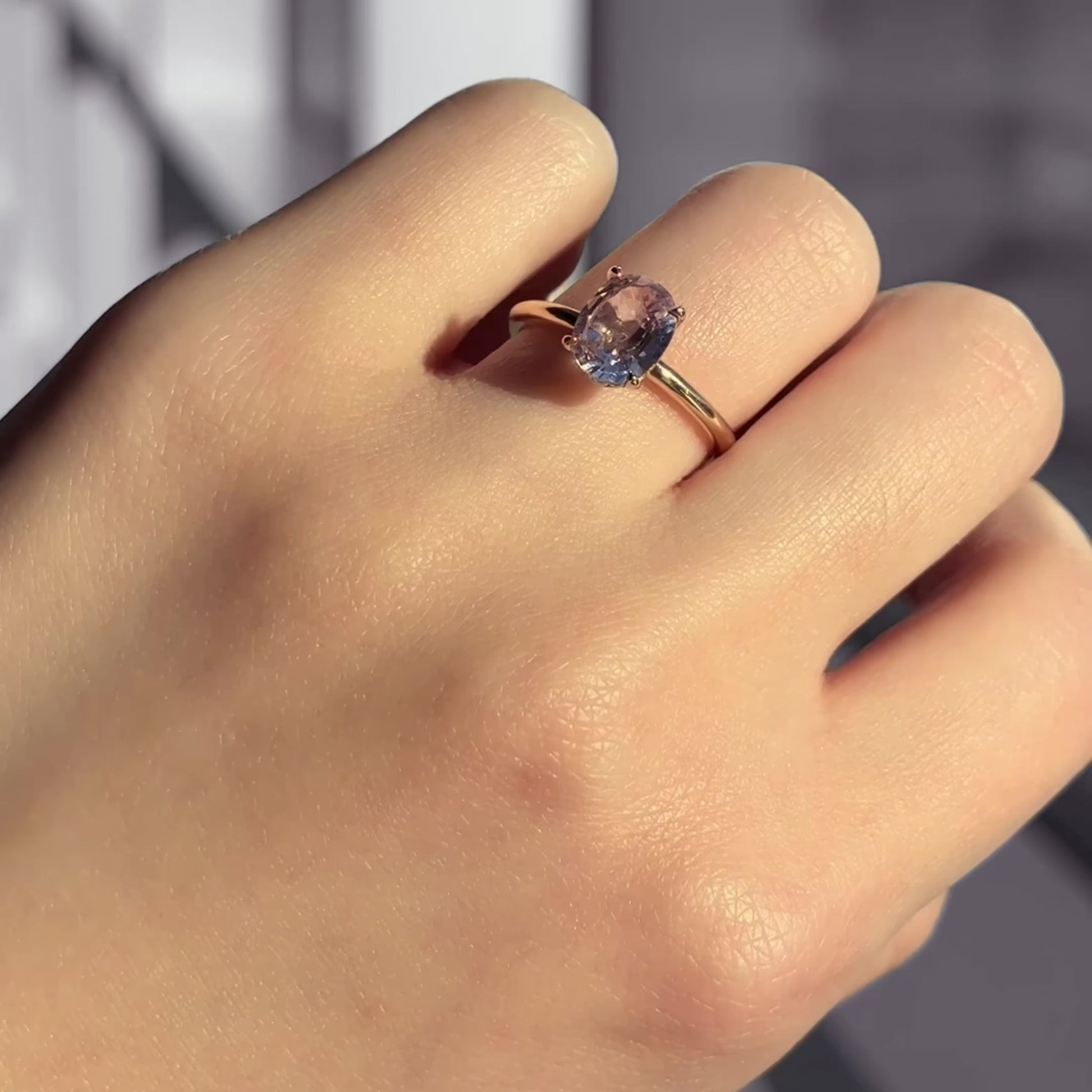 Hand wearing the Sweet Romance ring featuring a 1.72 carat unheated light pink sapphire from Madagascar, set in a 14k yellow gold band with a hidden diamond halo.