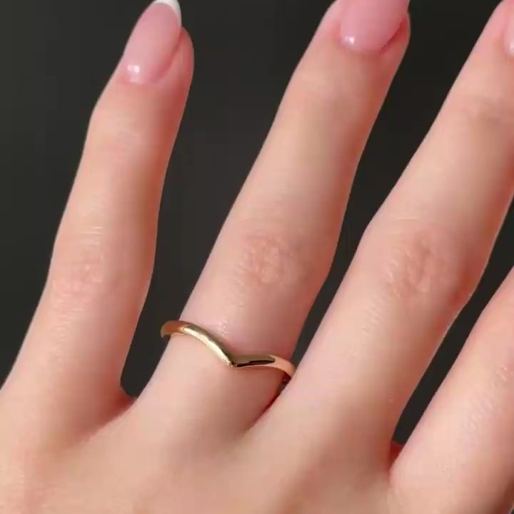 Video of the Veil ring, a slim curved gold band, shown on a hand against a dark background. Designed to sit beneath the Euphoric engagement ring.