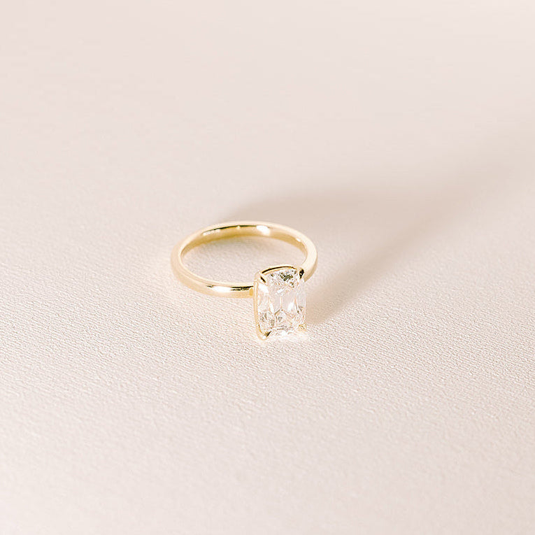 Old mine cut lab diamond solitaire ring in 14k yellow gold with 2.08 carat elongated centre stone on soft neutral background