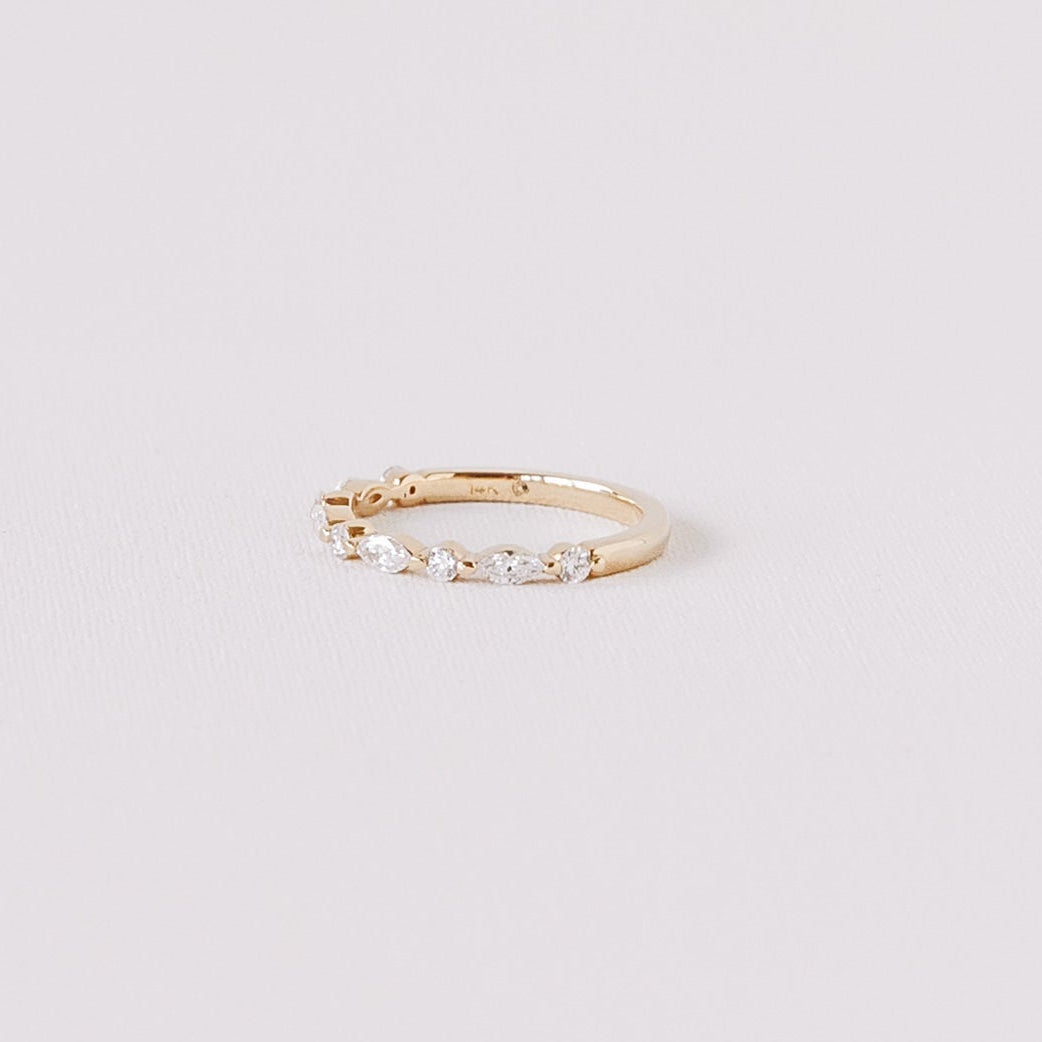 Marquise and round lab diamond half eternity wedding band in 14k yellow gold angled side view on white background