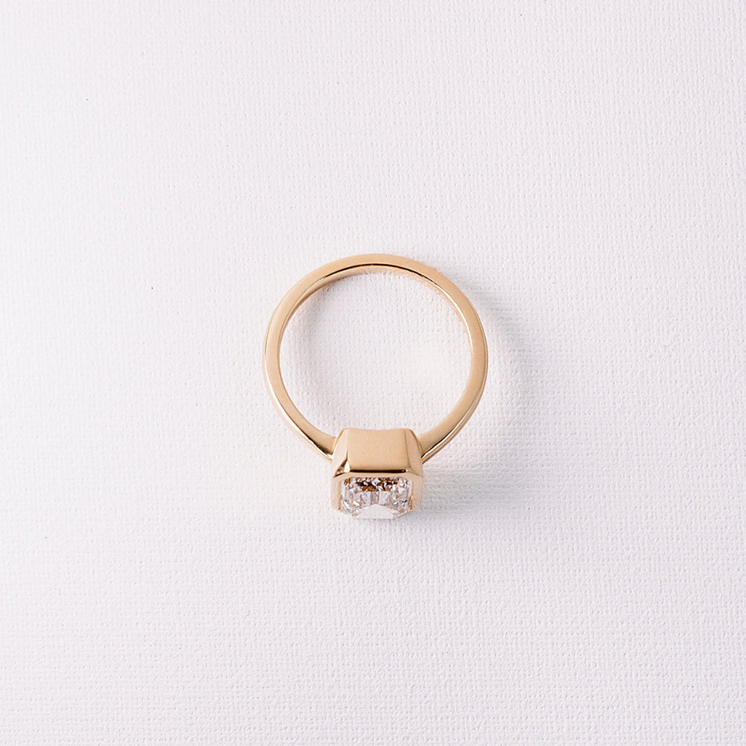 Ma Folie emerald-cut bezel lab diamond engagement ring in 14k yellow gold shown from above highlighting the full bezel setting and smooth band