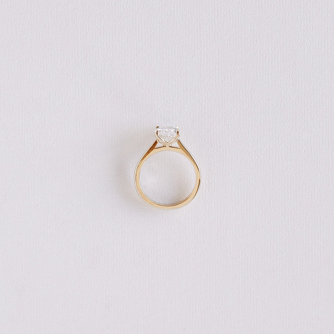 Oval lab-grown diamond solitaire ring with petal cathedral setting in 14k yellow gold, top-down view showing band symmetry