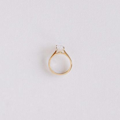 Oval lab-grown diamond solitaire ring with petal cathedral setting in 14k yellow gold, top-down view showing band symmetry