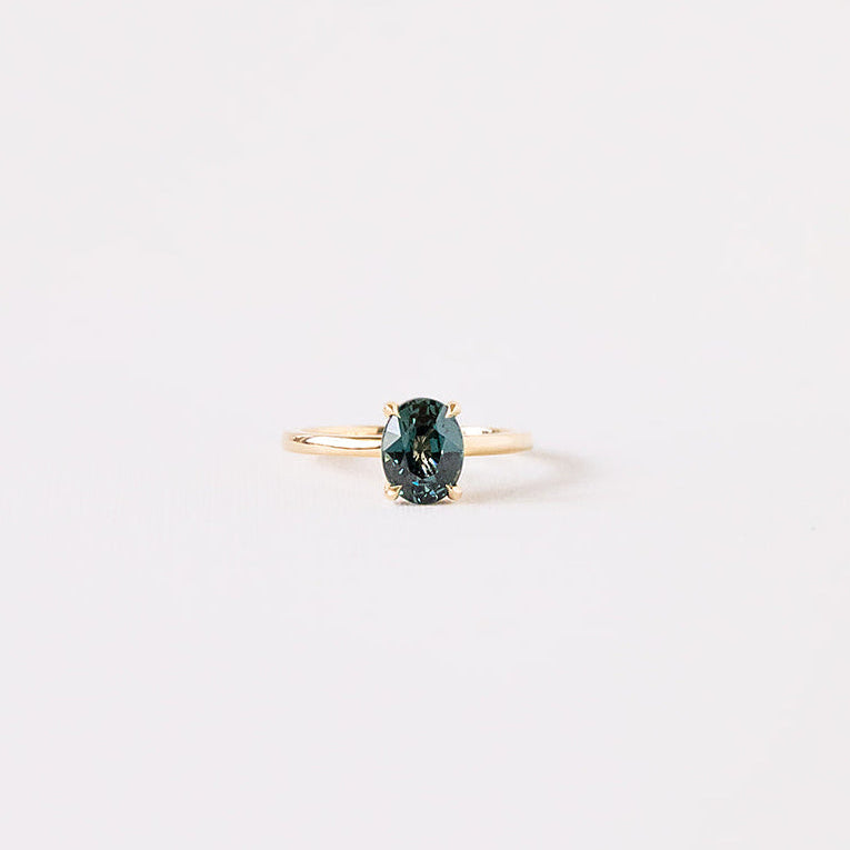 Teal green sapphire oval ring with yellow gold