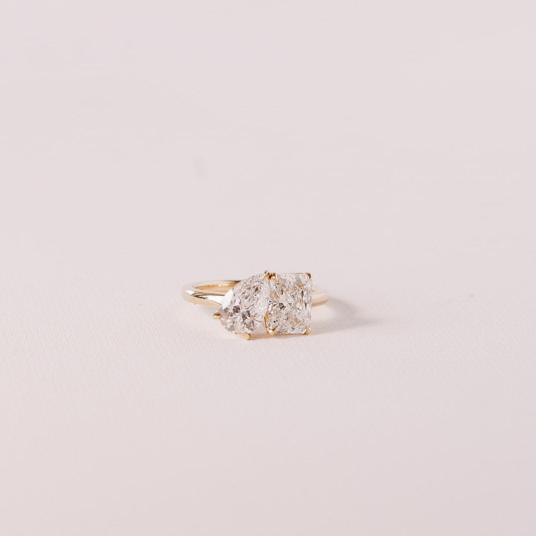 side angle of toi et moi gold ring with pear and radiant lab diamonds