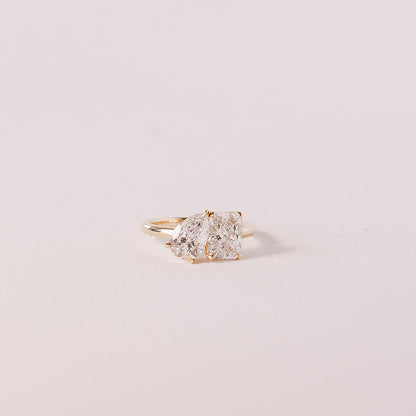 side angle of toi et moi gold ring with pear and radiant lab diamonds