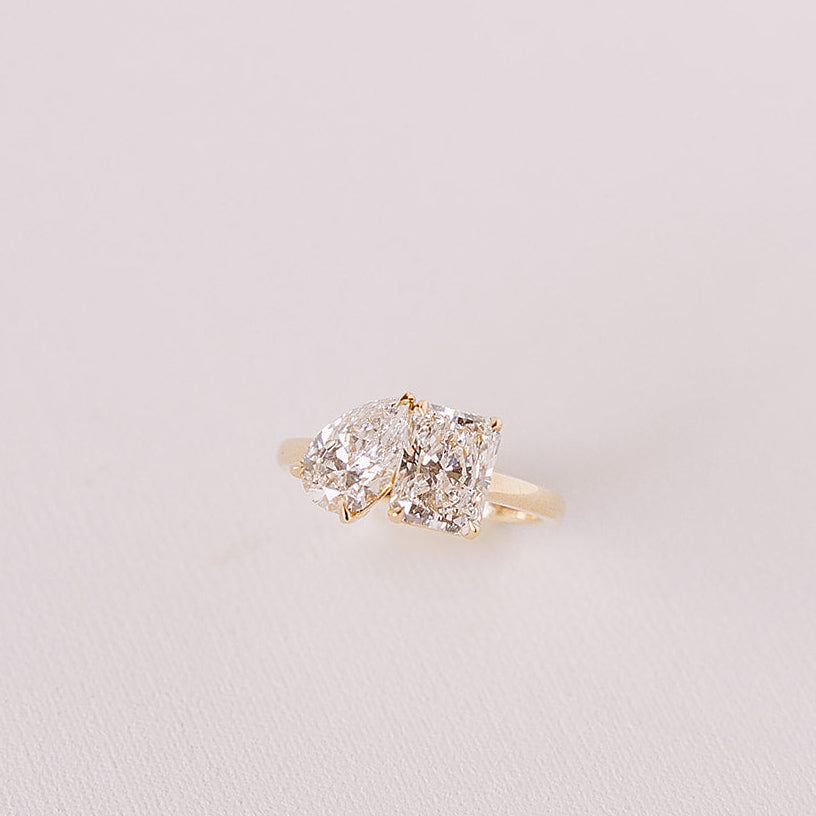 close-up front angle of toi et moi gold ring with pear and radiant lab diamonds