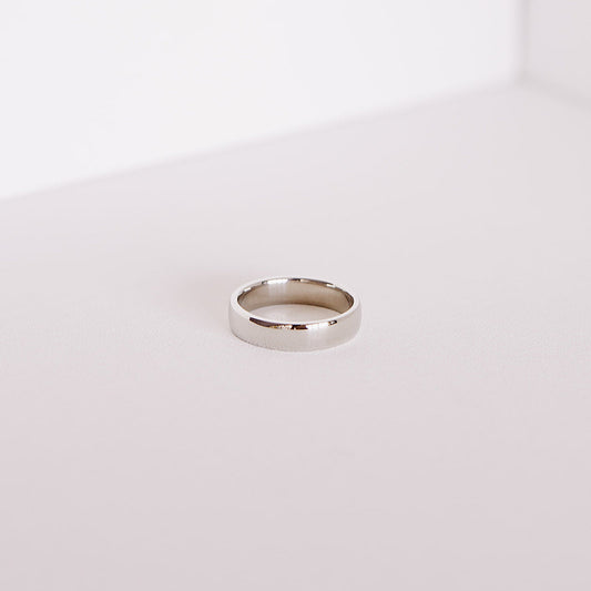 Front angle of the Espoused men’s wedding band in 14k white gold, showing the classic low-dome shape and high polish finish on a soft neutral background.