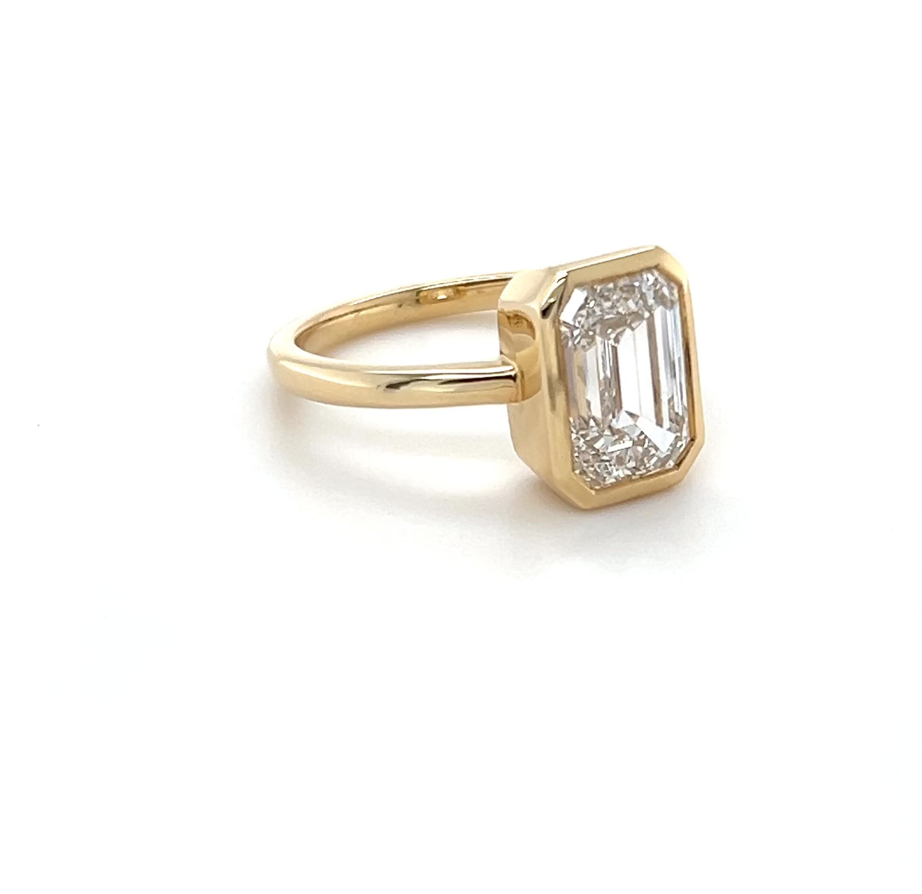 Ma Folie emerald-cut bezel lab diamond engagement ring in 14k yellow gold shown at all angles highlighting the depth of the bezel setting and diamond sparkle