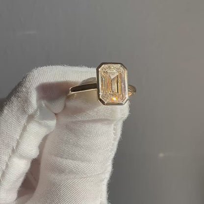 Emerald-cut bezel lab diamond ring in 14k yellow gold showing sparkle and angles, 2.53 carat D VVS2 centre stone