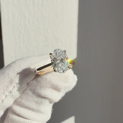Oval lab-grown diamond solitaire engagement ring in 14k yellow gold with cathedral petal setting showing sparkle and angles in natural light